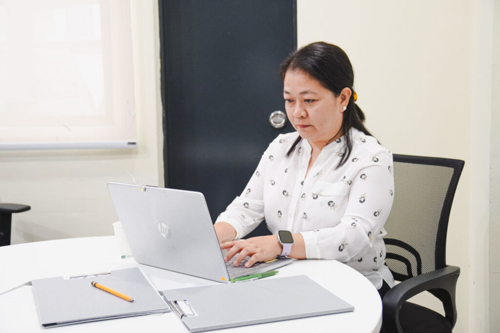 VizServe team member working on a laptop in a modern office setting.